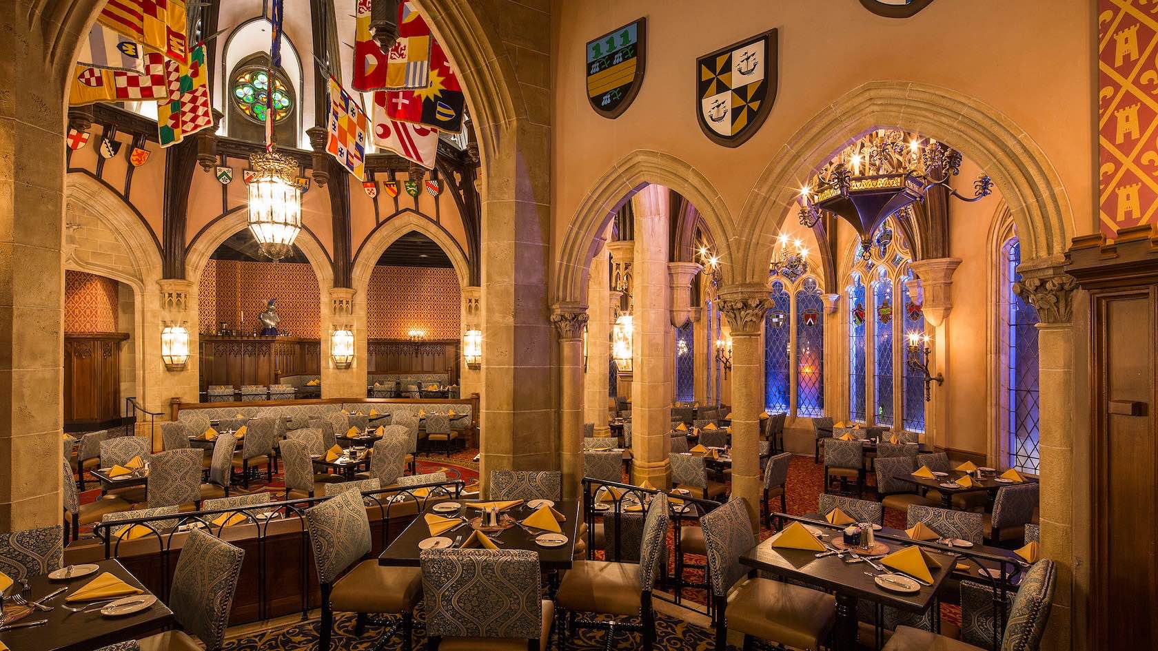 Internal picture of Cinderella's Royal Table Restaurant Disney World. Grand castle dining hall with stained glass windows.