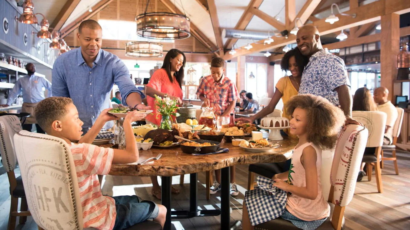 Internal picture of Story Book Dining Restaurant at Disney World. Family laughing at Grumpy character.