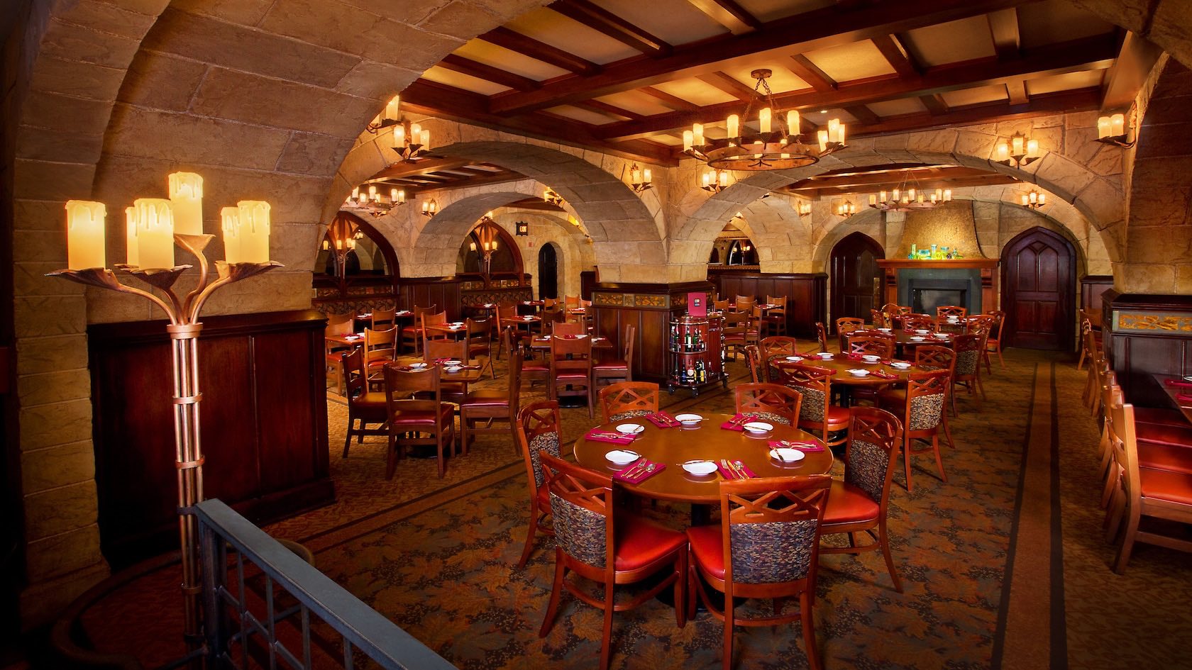 Internal picture of Le Cellier Steakhouse Restaurant Disney World. Elegant manor vibes with stained beams and candles.