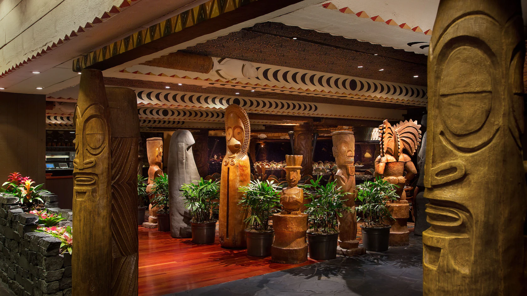 Internal picture of Ohana Restaurant Disney World. Polynesian inspired wooden tiki statues